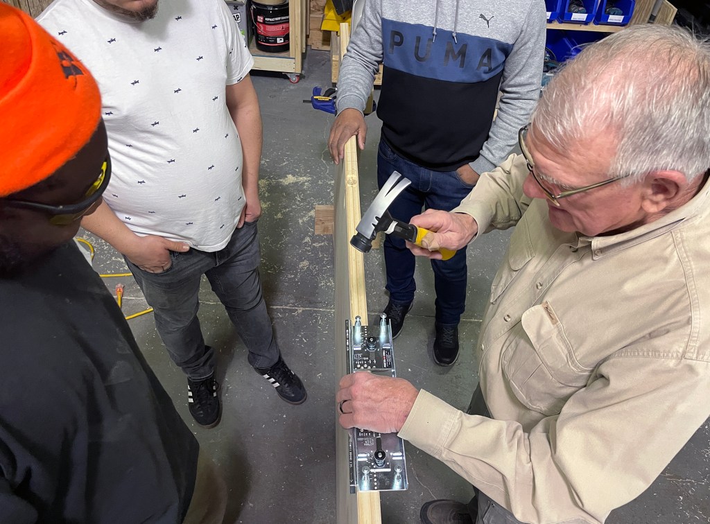 Joe Klopfenstein teaches students how to replace doors as part of a Rhode Island Housing program to certify lead-abatement contractors.