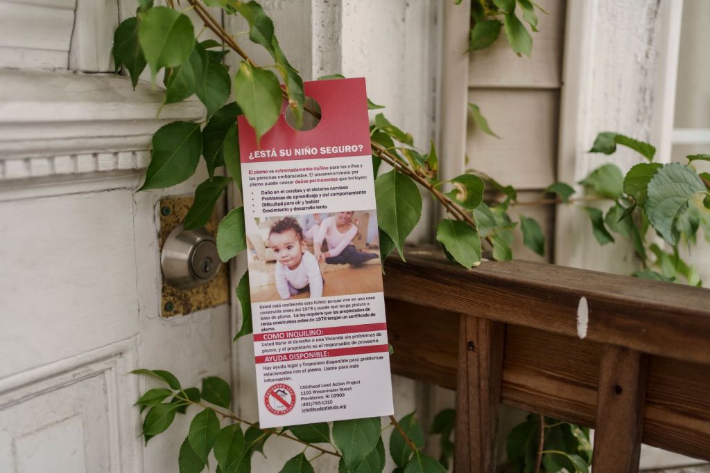 A door hanger describes the risks of lead poisoning in Spanish.